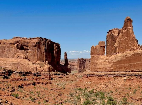 The view of the rocks at Park Avenue in Arches National Park: photo shows an expansive view of the landscape, with towering red and orange rocks