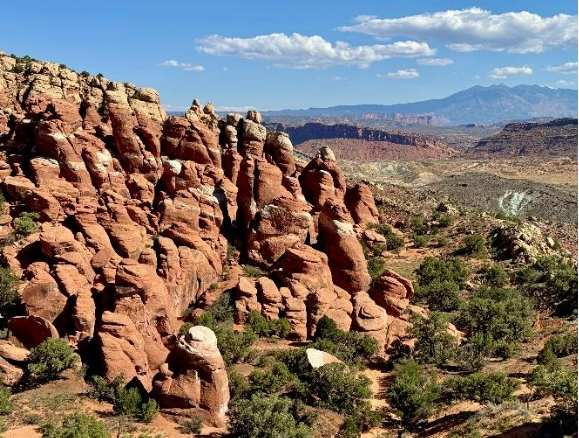 The view of the Fiery Furnace formations from the parking lot: they are striking, large, orange and white sandstone fins and hoodoos that cut across the landscape.