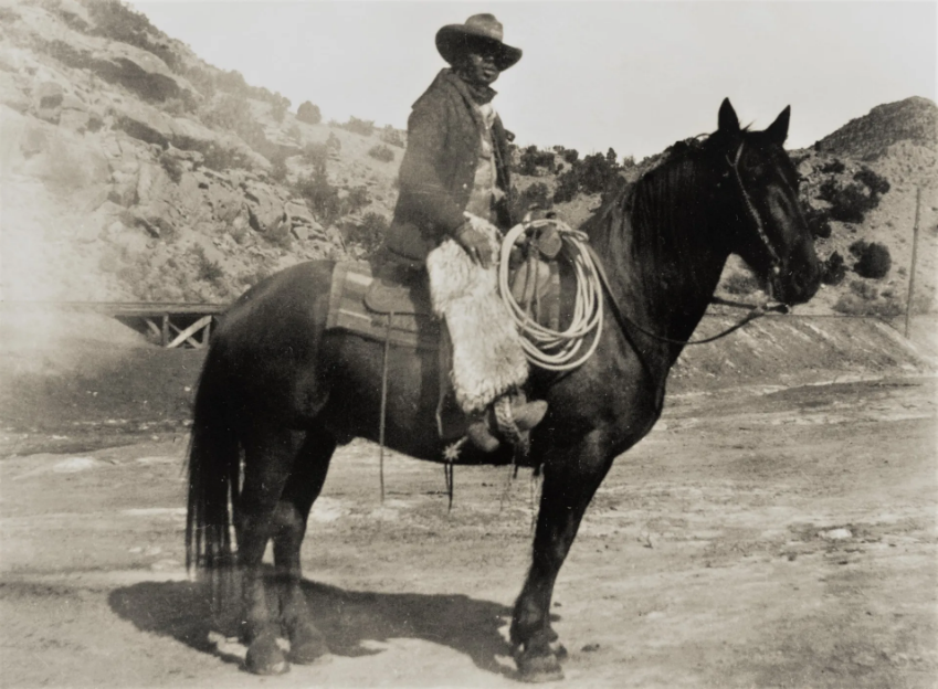 Charlie Glass, a local Moab cowboy, sitting on a horse: the photo is in black and white and is clearly older, as it's blurred.