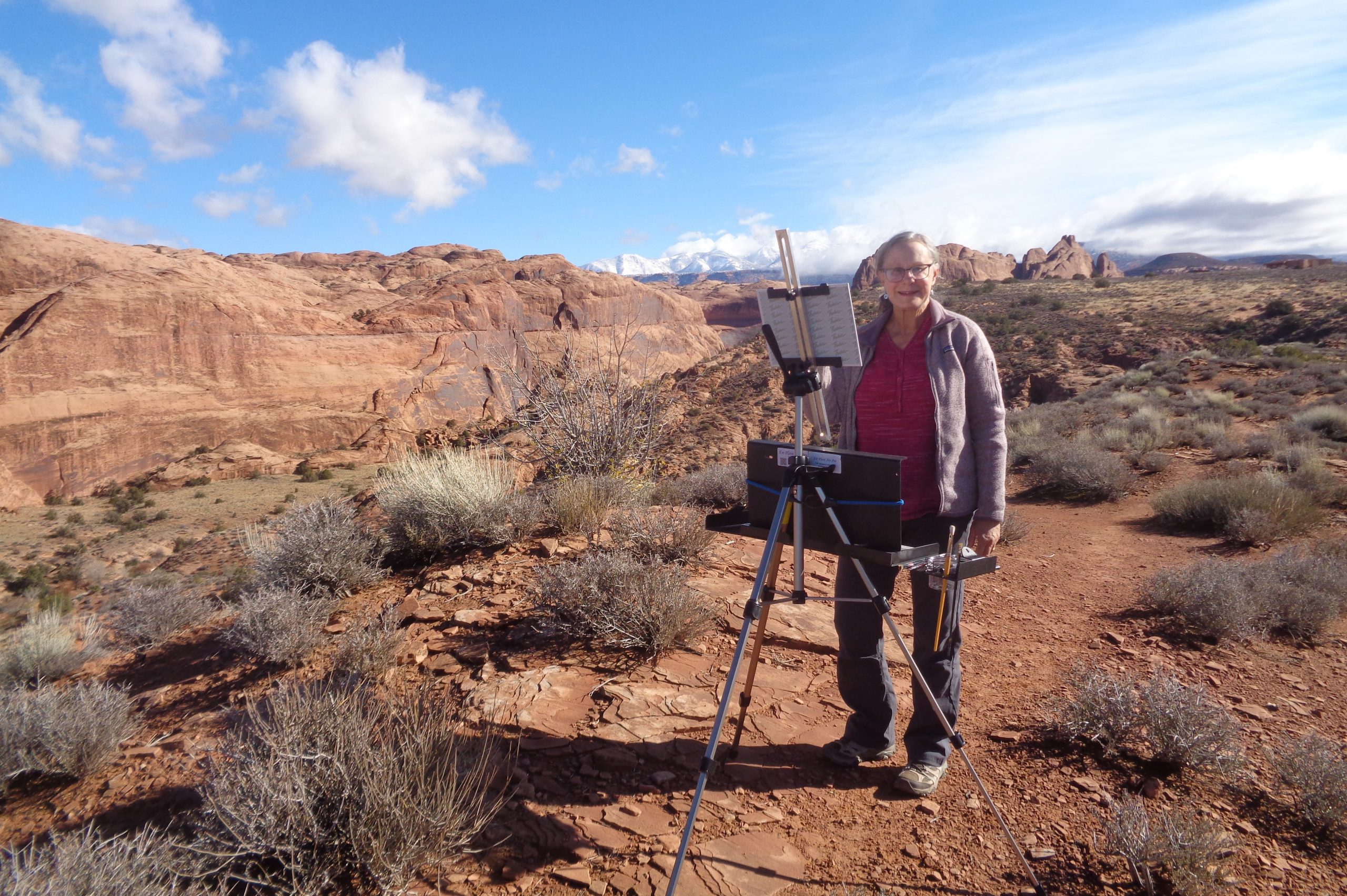 Charlotte Quigley, an older woman, posing with her easel on the upper Mill Creek Trail.