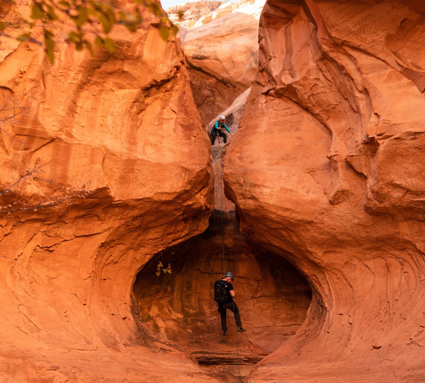 A person rappelling down Looking Glass Arch