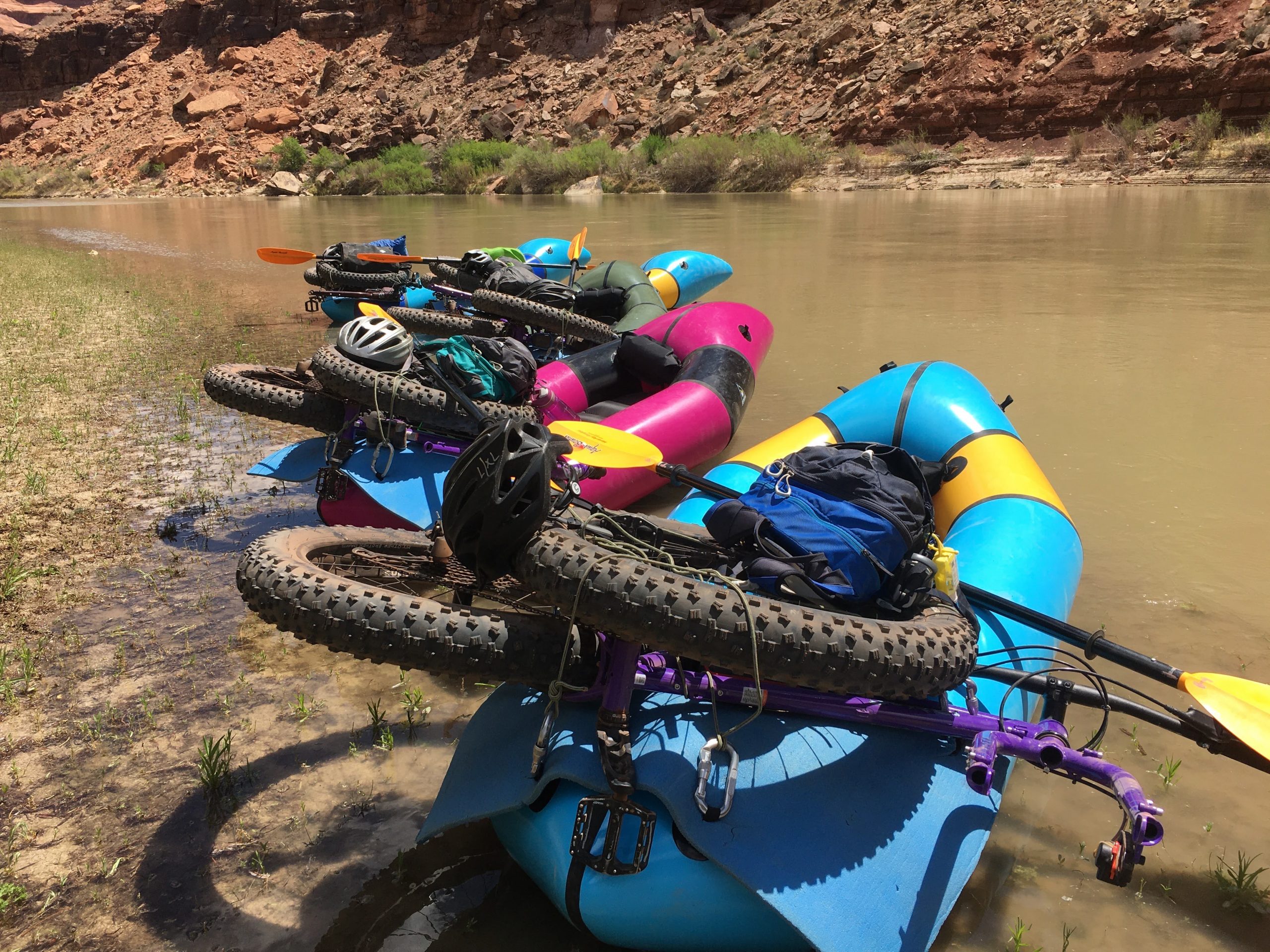 Two packrafts on the shore of a river with bikes in them