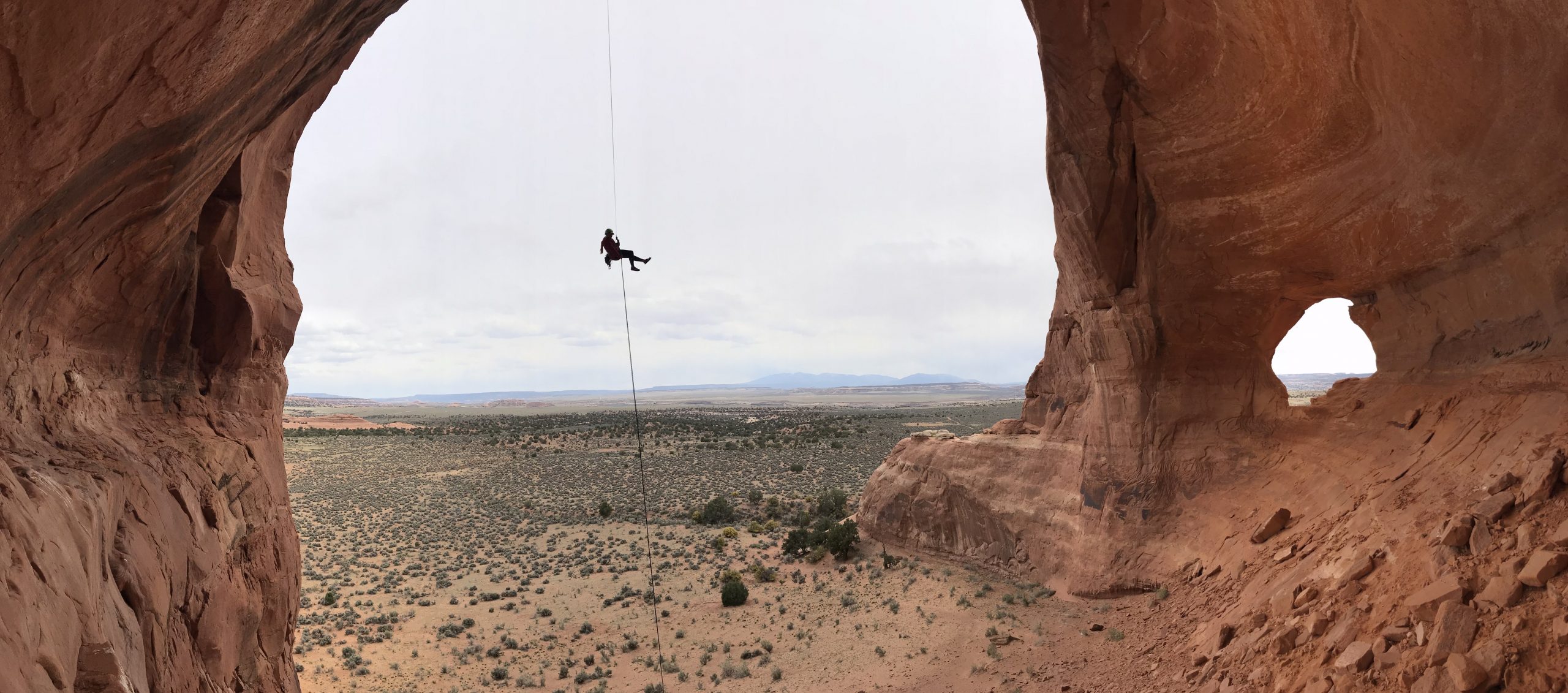 A person rappelling down Looking Glass Arch